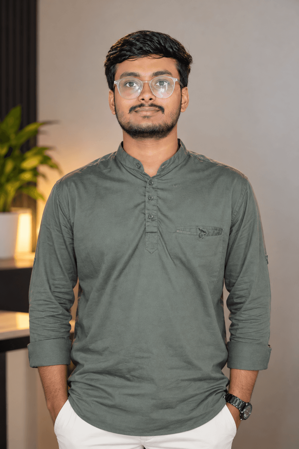 Hayat Ilyas, wearing glasses and an olive shirt